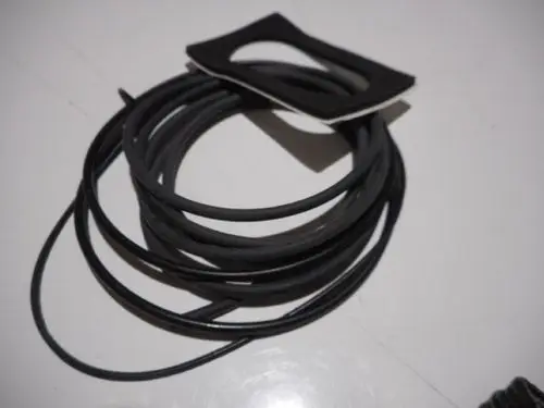 Schwarzes Gummiband und eine Dichtung auf einem weißen Untergrund, möglicherweise Teil eines Heizsystems von Remeha.